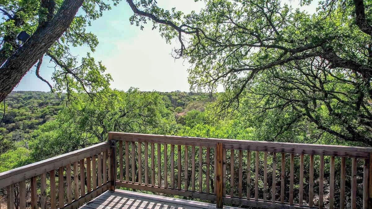 Una terraza de madera con vista a un paisaje boscoso.