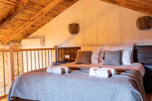 A bedroom with a wooden ceiling, a large bed with multiple pillows, a nightstand, and a wall-mounted air conditioner. - Villa Jokić Dvori (Benkovac)