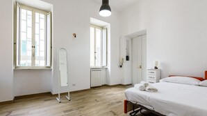 A bedroom with a bed, a dresser, a mirror, and a radiator. - Via Morghen 63 - Primo Piano (Naples)