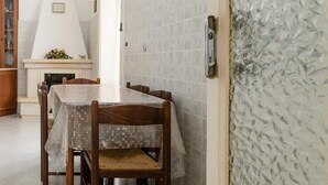 A dining area with a table and chairs, a fireplace, and a wall with a textured pattern.