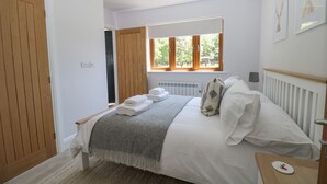 A bedroom with a bed, a window, a radiator, and a door. - Robins Nest (Fareham)