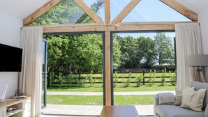 A spacious room with a large sliding glass door leading to a garden. - Robins Nest (Fareham)