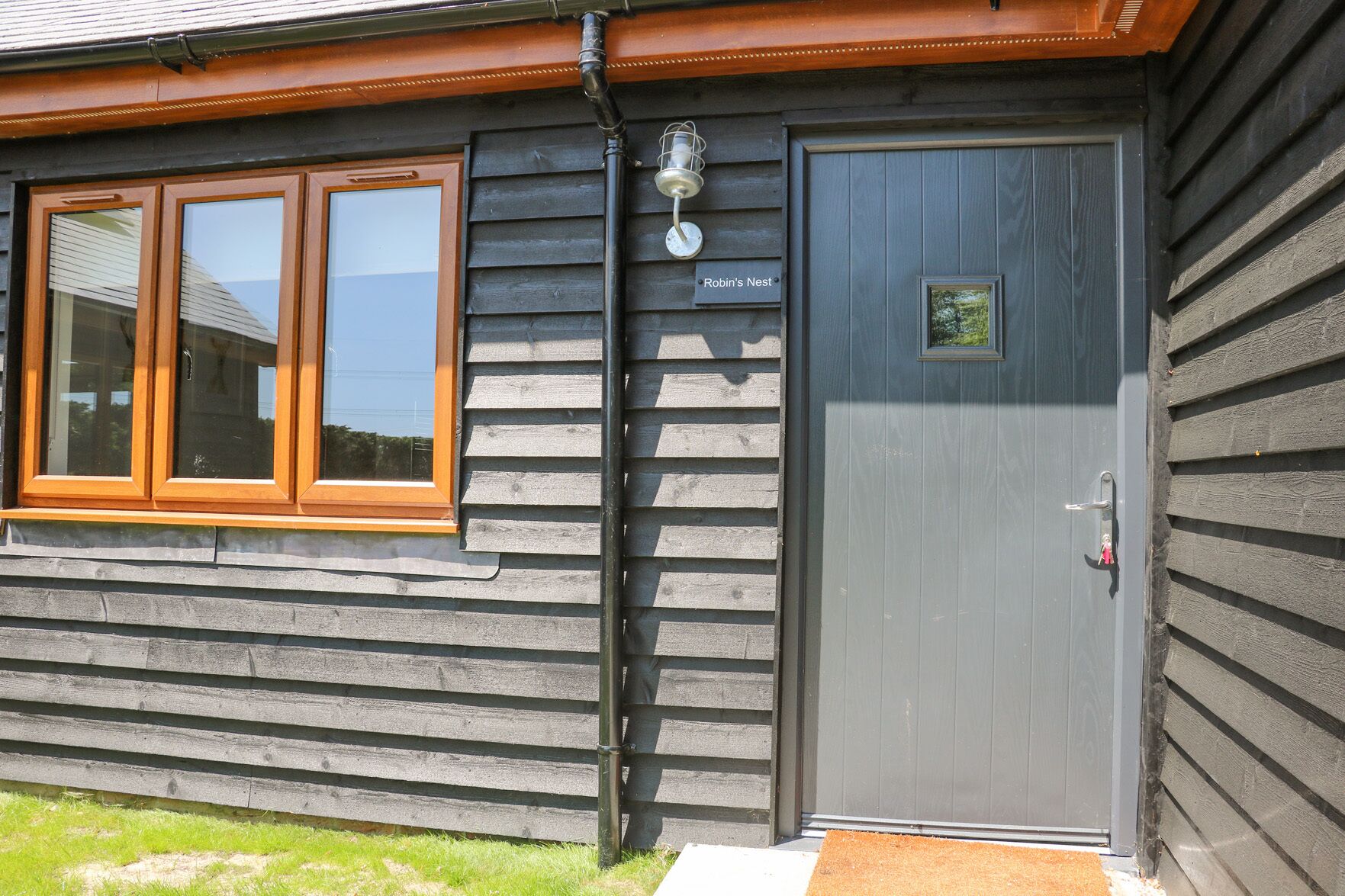 A wooden building with a grey door labeled "Robin's Nest."