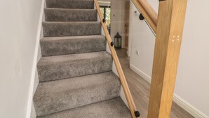 A staircase with carpeted steps and a wooden handrail. - Millhouses Hideaway (Sheffield)