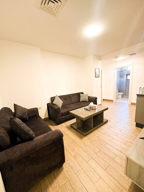 A living room with a dark brown sofa, a matching armchair, and a coffee table.
