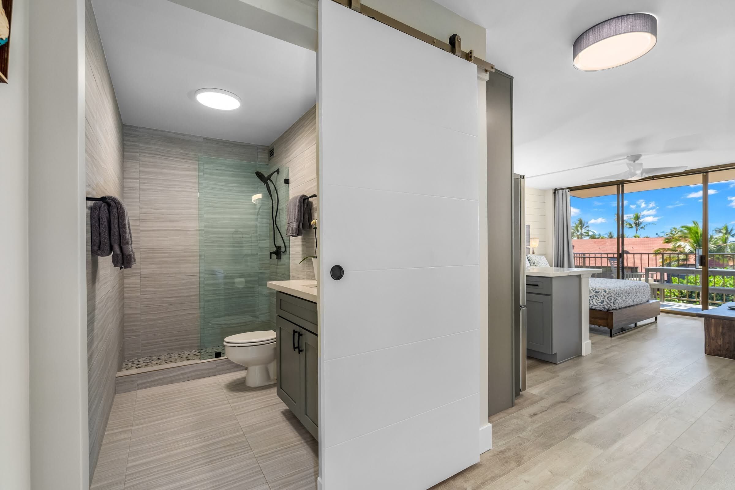 Een moderne badkamer met douche, toilet en wastafel.