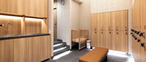 A modern bathroom with wooden cabinets, a bench, and a shower area.