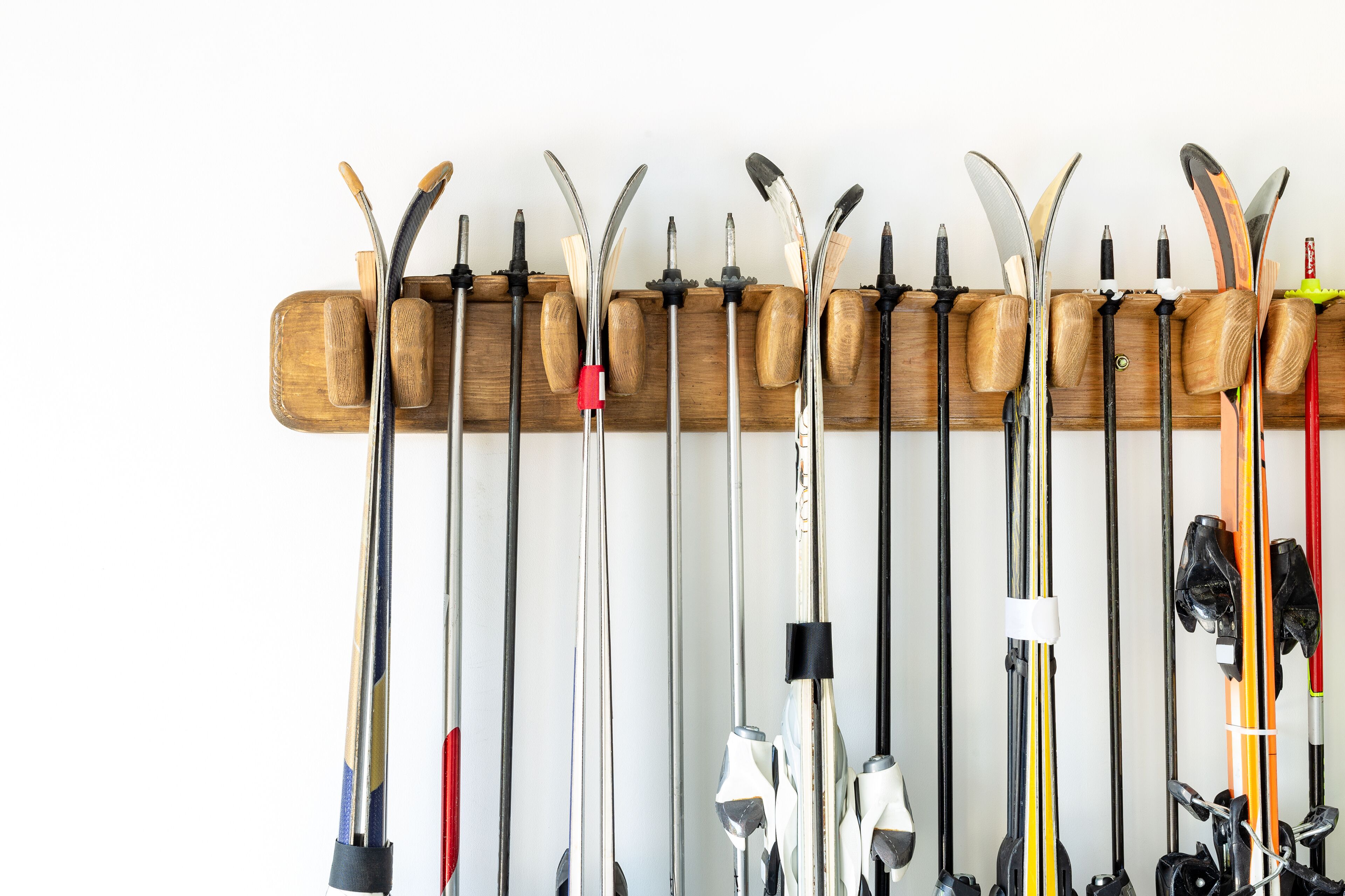 A wooden rack with skis and ski poles.