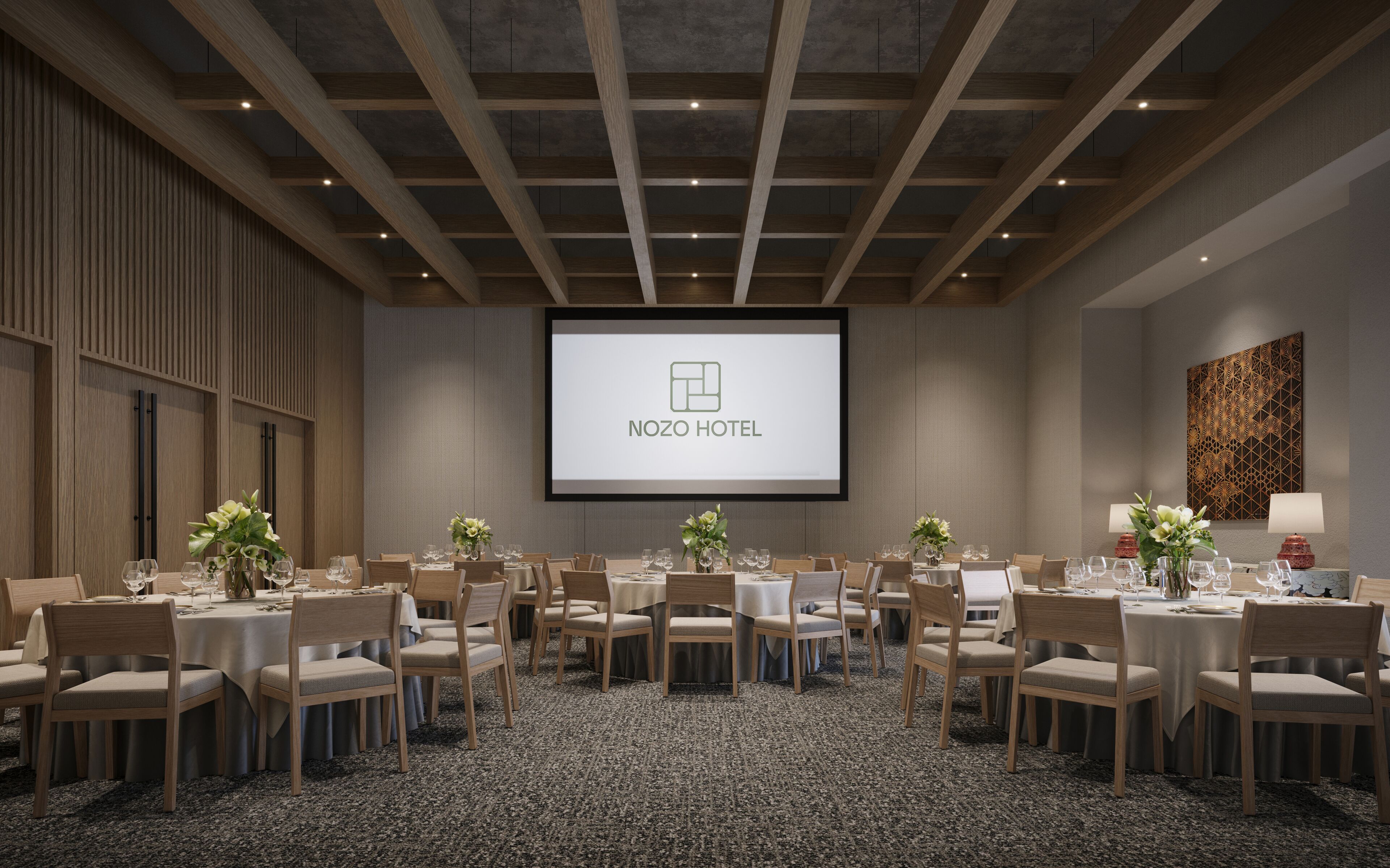 A conference room with a large screen displaying the NOZO HOTEL logo, arranged tables with chairs, and a carpeted floor.