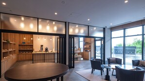 Een modern interieur met een ronde centrale tafel, zithoek en een keuken op de achtergrond.
