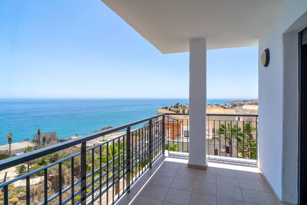 Un balcone con vista libera sul mare e sugli edifici in lontananza.