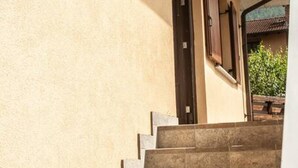 Un conjunto de escalones de piedra que conducen a una puerta con un pequeño ventanal encima.