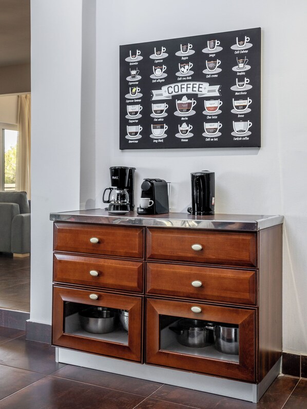 A coffee station with a coffee machine and a coffee maker on a wooden cabinet. - Relux Sea View Two Bedroom Apartment by BluPine (Athens)