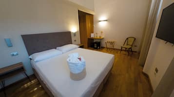 Une chambre d’hôtel avec un lit, une chaise, un bureau et un téléviseur.