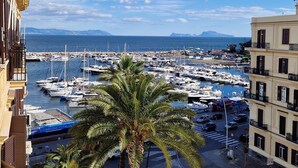 A marina with numerous boats docked, a clear sky, and a view of distant mountains. - Lungomare Suite & Spa (Naples)