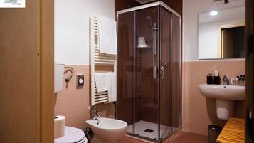 Une salle de bain avec une douche, un lavabo et des toilettes.