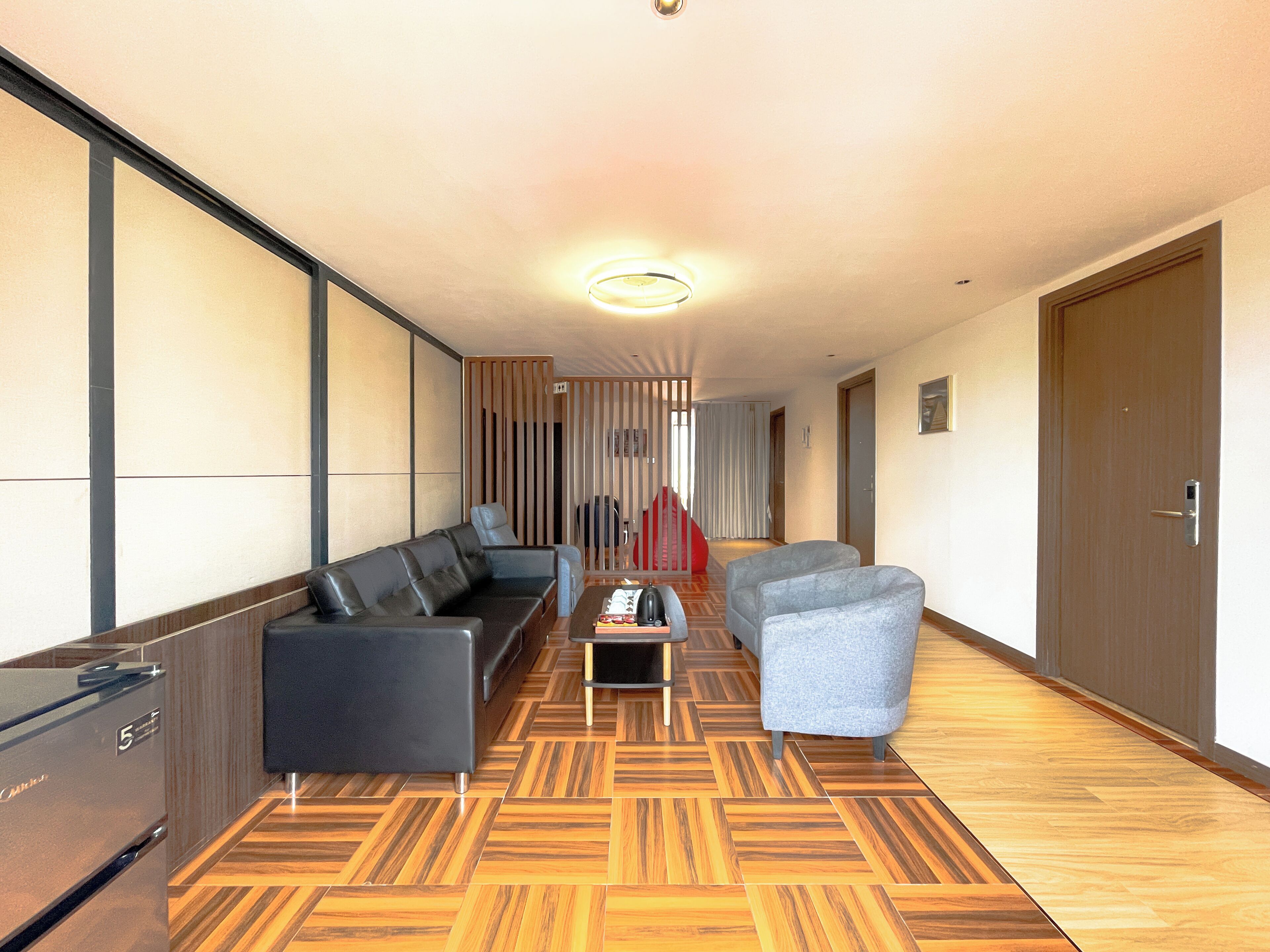 A hallway with a sofa, armchairs, a small table, and a door.
