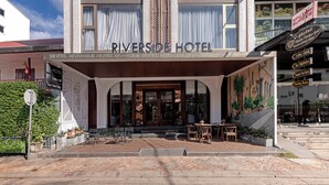 The Riverside Hotel with a prominent entrance, outdoor seating area, and visible signage for amenities like a coffee shop and meeting room. - Riverside Hotel (Vientiane)