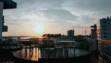 Enjoy panoramic city views from this rooftop terrace with tables and chairs for dining or relaxation.