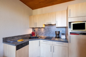 Een koelkast, een magnetron, een kookplaat, een vaatwasser