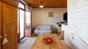 Interior de madera con una mesa de comedor, un sofá y una pared de ladrillo blanco.