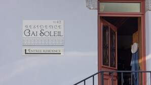 Entrada de un edificio con un cartel que indica 'Residence Gai Soleil' y 'Entrée Residence'.