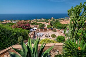 Une station balnéaire avec vue sur la mer, des cactus et un espace piscine.