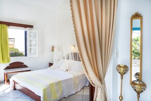 A bedroom with a bed, bedside table, lamp, and a mirror on the wall.