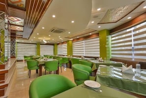 Enjoy meals in a beautifully set dining area with tables, chairs, and a decorative ceiling.