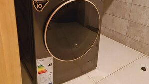 A compact, modern washing machine with a digital display and a control panel. - Luxury Modern 3bdr with a pool and  gym (Nairobi)