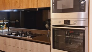 A modern kitchen with stainless steel appliances, a built-in oven, and a microwave. - Luxury Modern 3bdr with a pool and  gym (Nairobi)