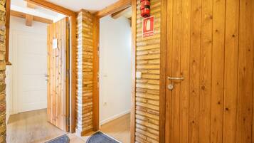 Una puerta de madera con un extintor montado encima y un felpudo en la entrada.