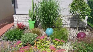 Un jardín con diversas plantas y elementos decorativos.