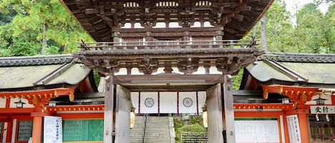 A traditional Japanese gate with a wooden structure and a tiled roof.
