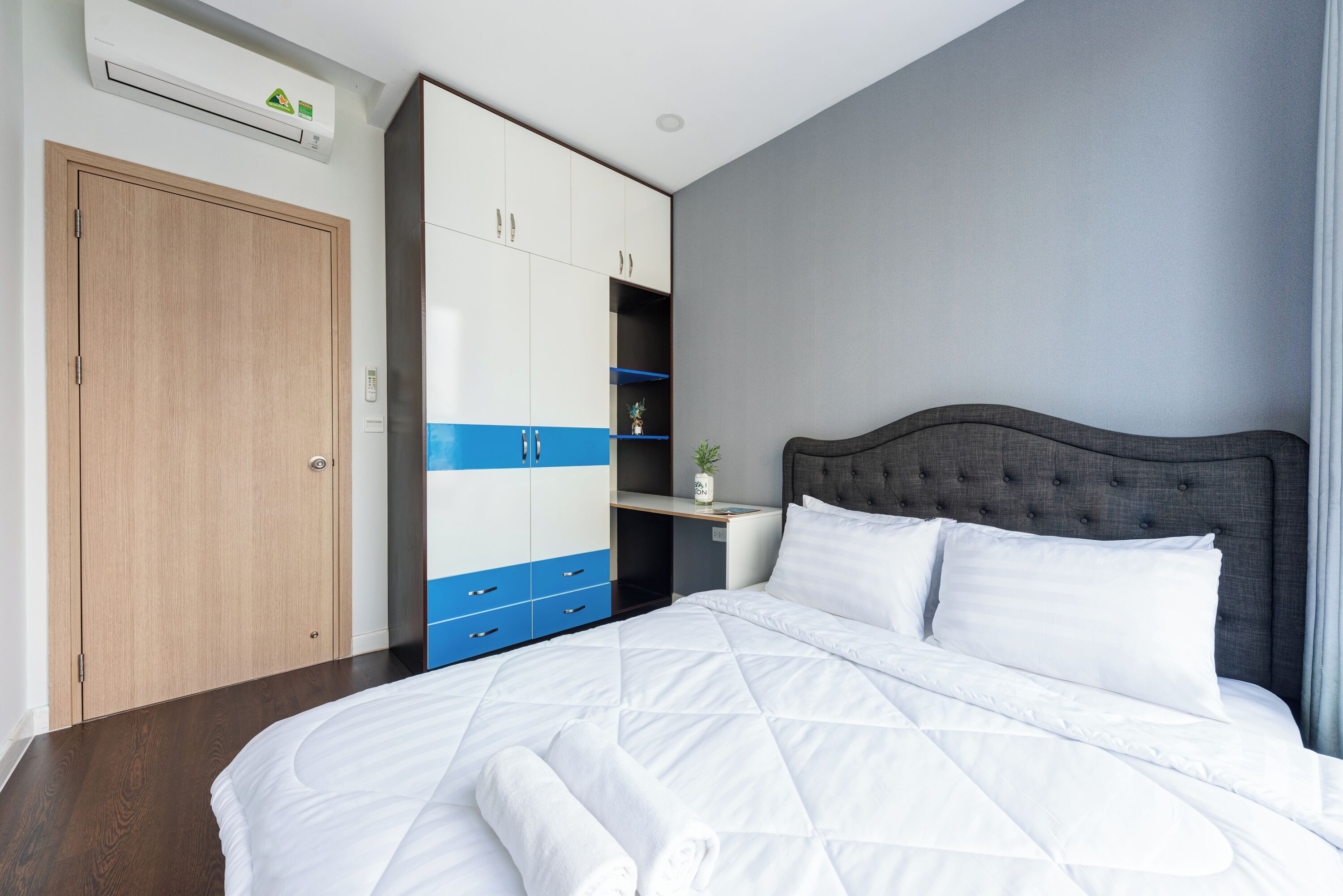 Een slaapkamer met een groot bed, een kledingkast en een nachtkastje.
