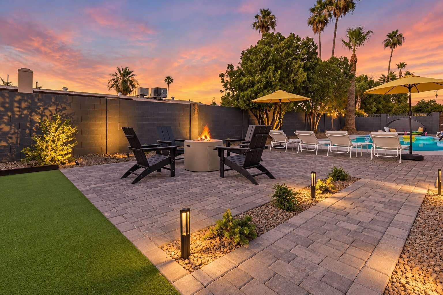 An outdoor patio with a fire pit, seating, and a pool area.
