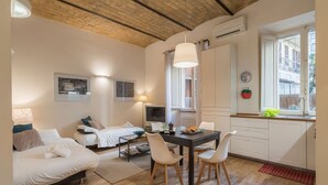 Una habitación acogedora con cama, escritorio y zona de comedor.