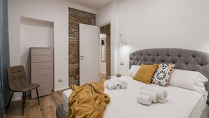 Une chambre à coucher comprenant un lit, une chaise, une armoire et une porte donnant sur une autre pièce.