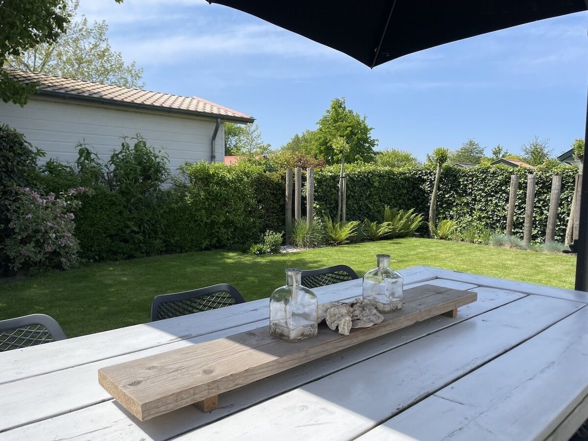 Une table en bois recouverte d’une nappe blanche, trois bocaux en verre contenant une substance blanche et un plateau en bois.