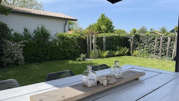 Une table en bois recouverte d’une nappe blanche, trois bocaux en verre contenant une substance blanche et un plateau en bois.