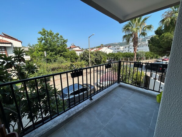 A balcony with a view of a residential area, including houses and parked cars. - Avlu Villas & Apartments (Kemer)