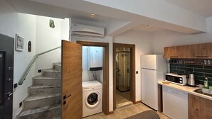 Cocina compacta con lavadora, refrigerador y microondas.