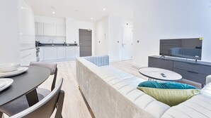 A modern apartment with a kitchen, dining area, and living room. - Stylish 2BR Solihull Flat, Quick Train to NEC (Birmingham)