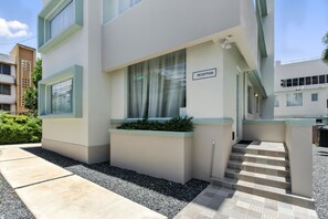 A modern building with a reception area, a staircase, and a small garden.