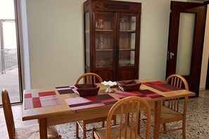 Ein Essbereich mit einem Holztisch, vier Stühlen und einer Vitrine mit Glastür.