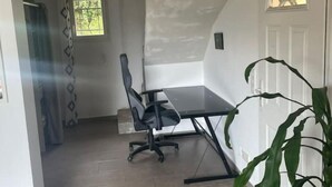 A room with a dining table and chairs, a potted plant, and a door with a window. - Villa au Calme (Draguignan)