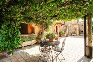 Relax in a tranquil outdoor space with a round table, four chairs, and a potted plant.