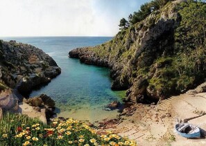 A coastal landscape with rocky cliffs, clear blue water, and a boat on the shore. - Corte dei Fiori (Diso)