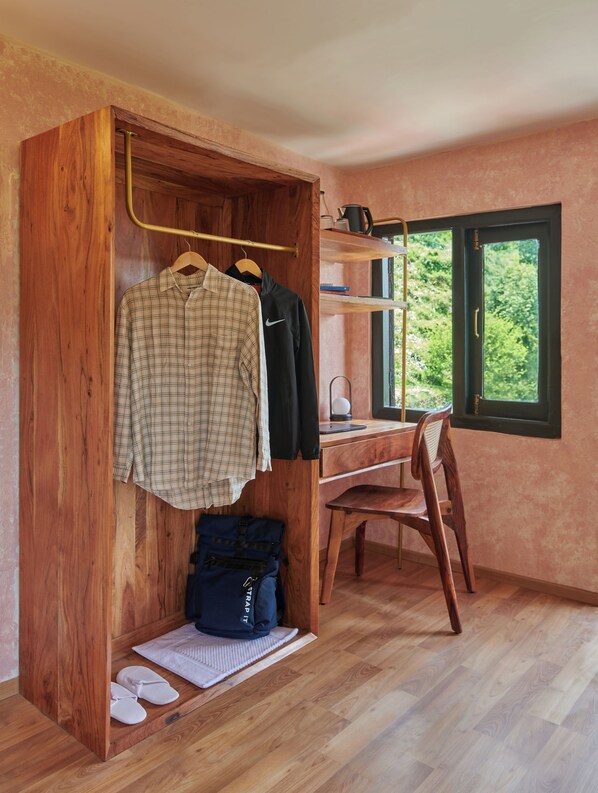 A bedroom with a wooden wardrobe, a desk, and a chair.