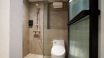 Ein modernes Badezimmer mit Duschkabine aus Glas, einer weißen Toilette und einem Handtuchhalter.